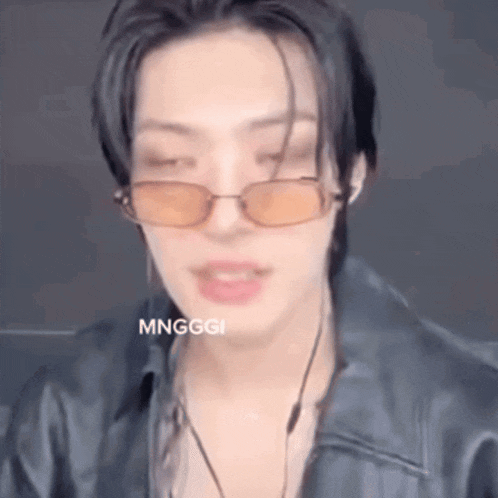 a close up of a person wearing sunglasses and a black leather jacket .