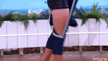 a woman is dancing on a hula hoop in front of a fence .