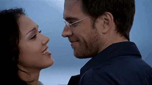 a man and a woman are looking into each other 's eyes and smiling