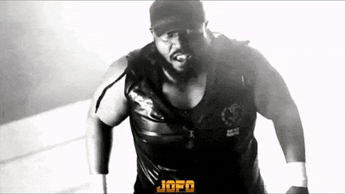 a black and white photo of a wrestler wearing a hat and a vest .