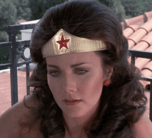 a close up of a woman wearing a tiara with a red star