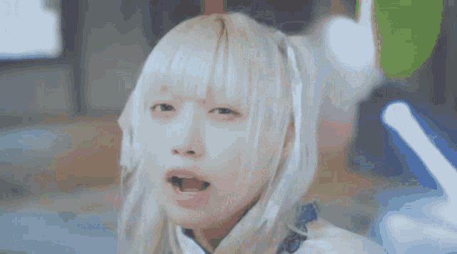 a girl with blonde hair is making a funny face with her mouth open