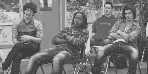 a group of people are sitting in chairs with their arms crossed .
