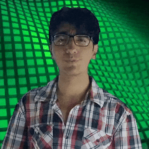 a man wearing glasses and a plaid shirt has a green background behind him