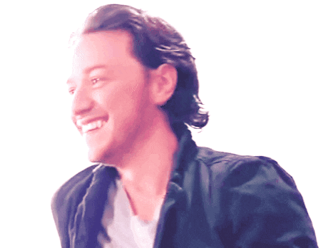 a man in a black jacket is smiling and looking to the side