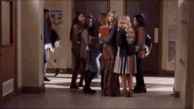 a group of girls standing in a hallway with a poster on the wall that says butterfly on it