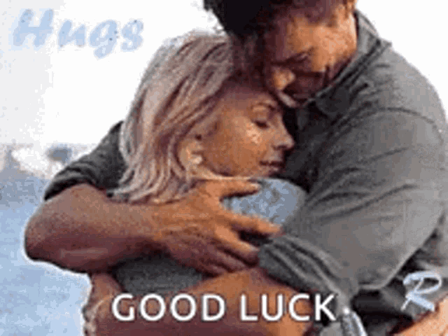 a man and a woman hugging each other with the words `` good luck '' written on the bottom .
