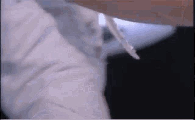 a close up of a person 's arm with a white shirt on and a black background .