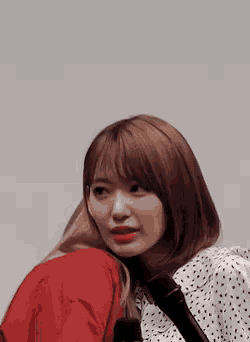 two girls are hugging each other and one is wearing a polka dot shirt