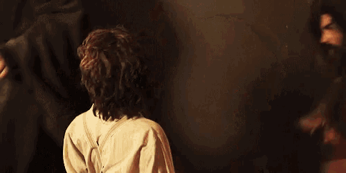 a man and a woman are standing next to each other in a dark room looking at each other .