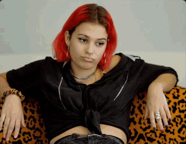 a woman with red hair is sitting on a couch