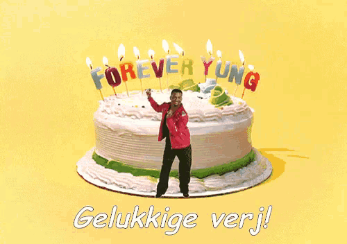 a man stands in front of a cake with candles that say forever young