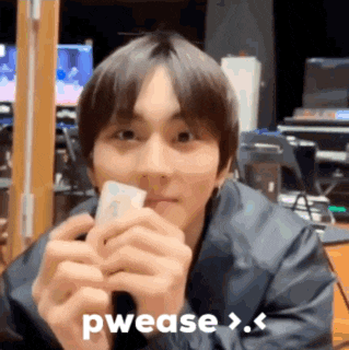 a young man is holding a piece of paper in his hands and says pwease > .
