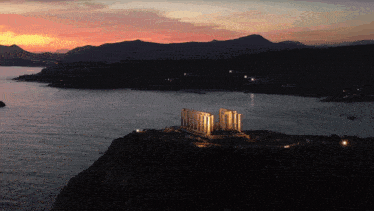 a large building sits on top of a cliff overlooking the ocean