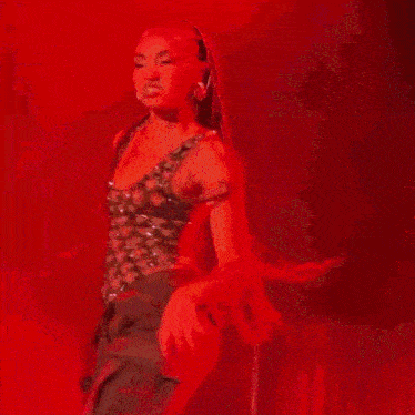 a woman is singing into a microphone on stage .