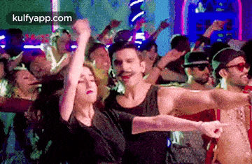 a man and a woman are dancing in front of a crowd .