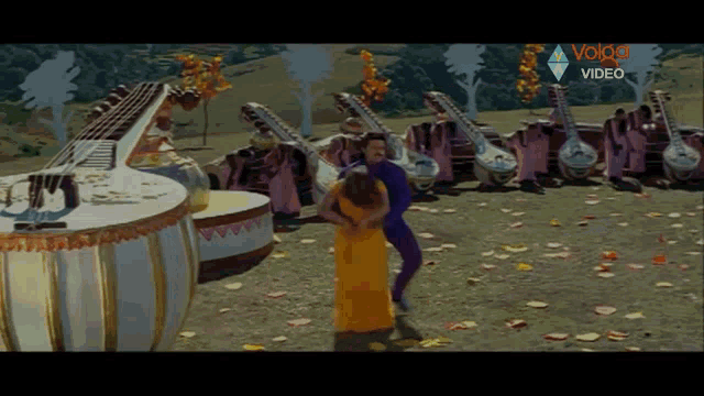 a man and a woman are dancing in front of a row of musical instruments and the words volco video are on the screen