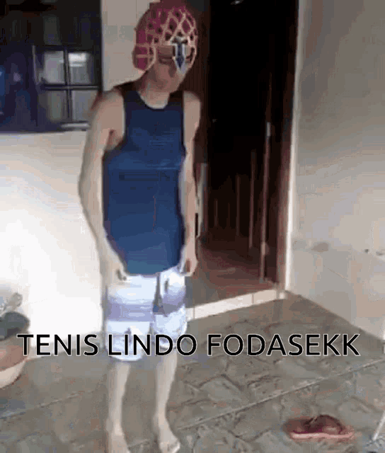 a man in a blue tank top and shorts is standing in a room with the words tenis lindo fodasekk written on the floor