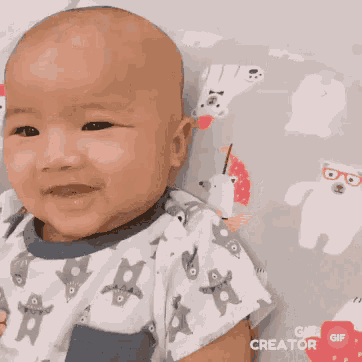 a baby is smiling with a gif creator icon in the corner