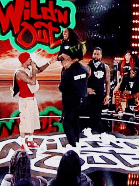 a group of people standing on a stage in front of a sign that says " wild n out "
