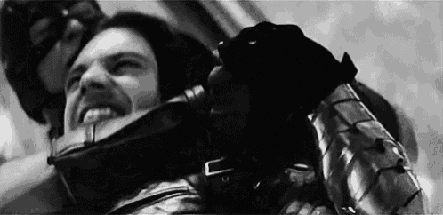 a black and white photo of a man in a mask holding another man 's neck .