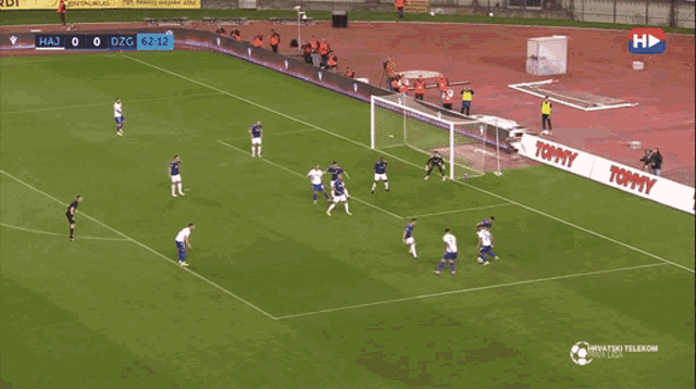 a soccer game is being played on a field that has a tommy banner