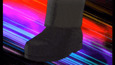 a person 's foot is standing in front of a rainbow of lights
