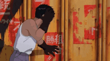 a man covering his face with his hands in front of a wall with chinese writing