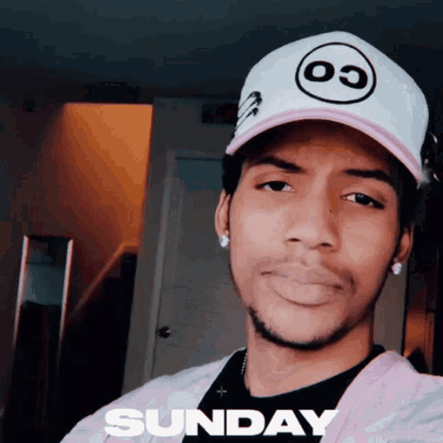 a man wearing a white hat and a pink jacket with the word sunday below him