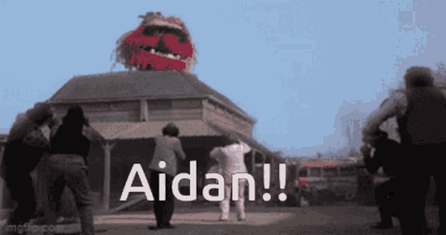 a group of people are standing in front of a building with the words aidan written on it