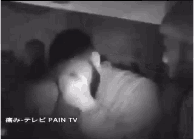 a black and white photo of a man with pain tv in the corner