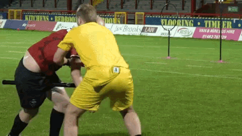 a man in a yellow shirt with the number 4 on his back is fighting another man in a red shirt