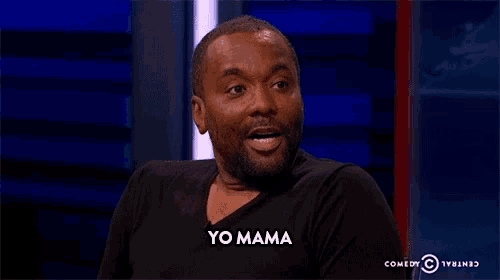 a man in a black shirt is sitting in front of a blue wall and says yo mama .