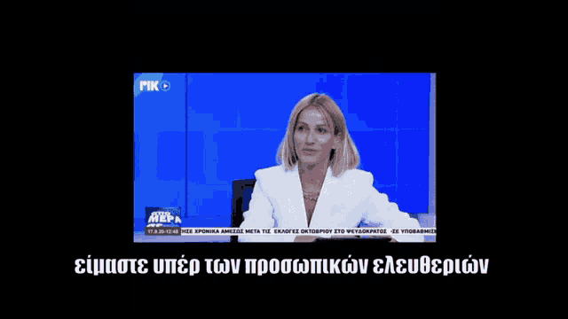 a woman in a white suit is on a television screen with a mik logo