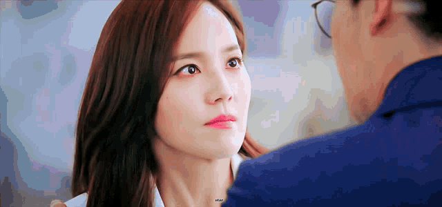 a man and a woman are looking at each other . the woman is wearing pink lipstick .