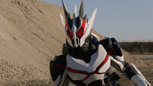 a black and white robot with a red stripe on the chest is standing in front of a pile of dirt