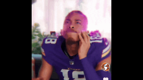 a football player wearing a purple jersey with the number 18 on it