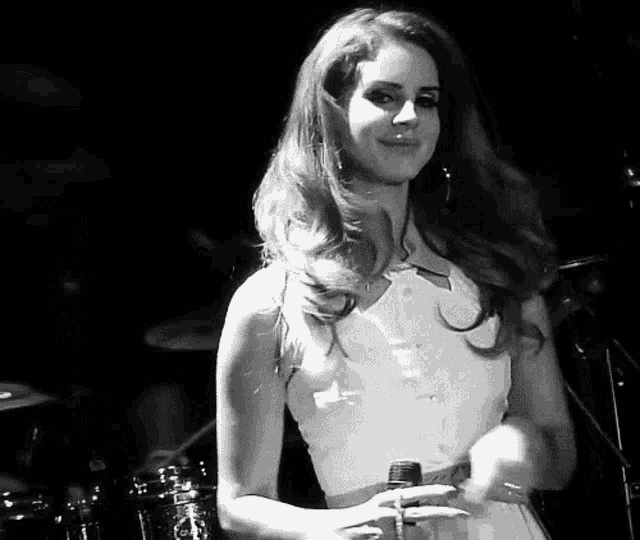 a woman is singing into a microphone in a black and white photo