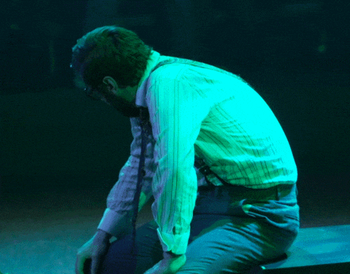 a man in a striped shirt and tie is kneeling down