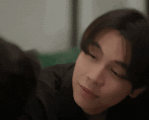 a close up of a person 's face with their eyes closed and a blurry background .