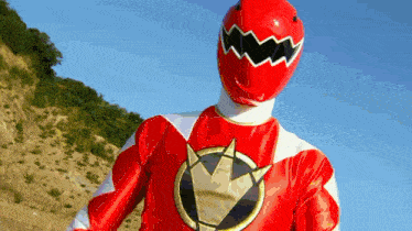 a red power ranger stands in front of a hill