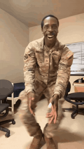 a man in a military uniform is smiling and holding something in his hand