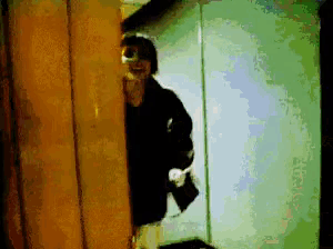 a man in a black jacket is standing in a room