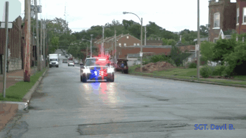 a police car is driving down a street with the words sct devil 8 on the bottom right