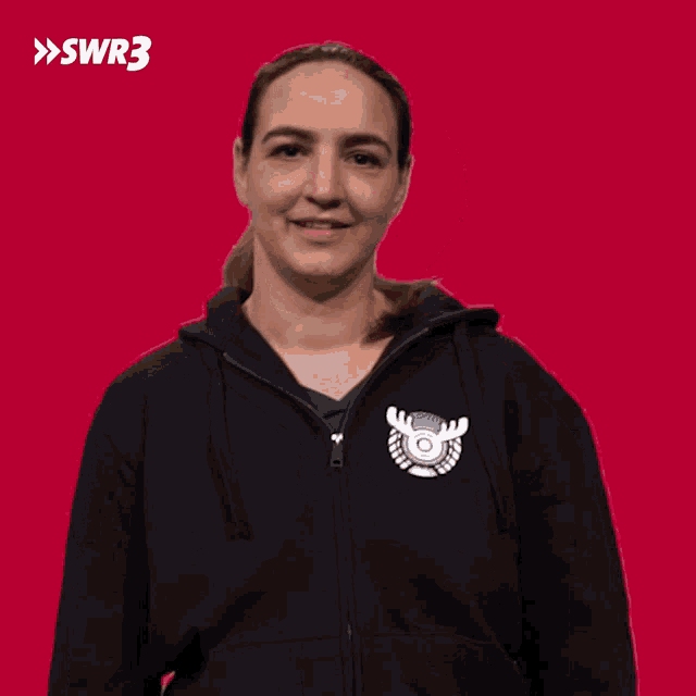 a woman wearing a black hoodie with a moose logo on the front