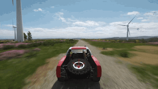 a red and white truck is driving down a dirt road