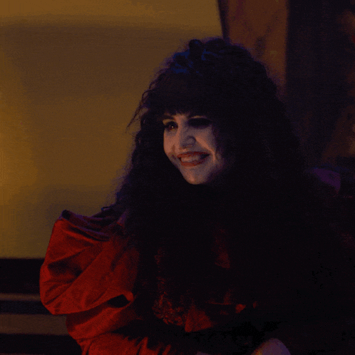 a woman in a red dress is smiling and holding something