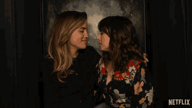 two women kissing in a photo booth with a netflix logo