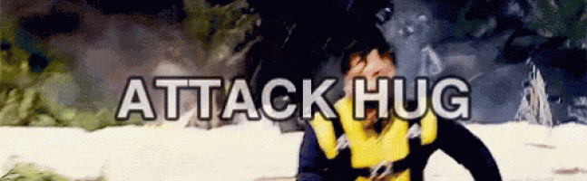 a man in a yellow and black jacket is standing in the snow with the words attack hug written above him .
