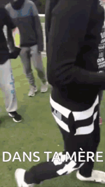a group of people are standing on a field with the words dans ta mere written on the bottom